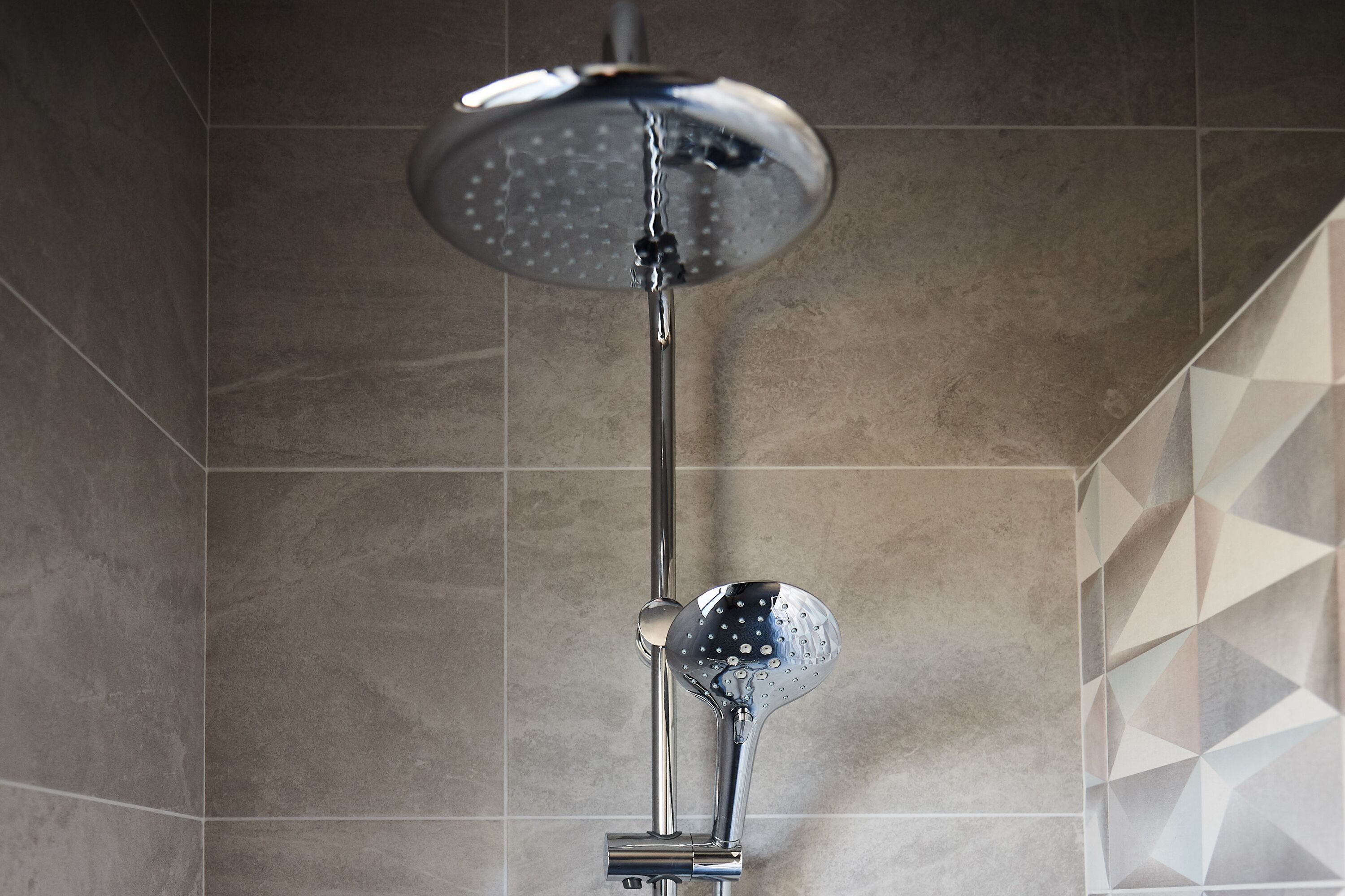 Ducha de diseño moderno, con cabezal de ducha tipo lluvia y un accesorio de ducha de mano.