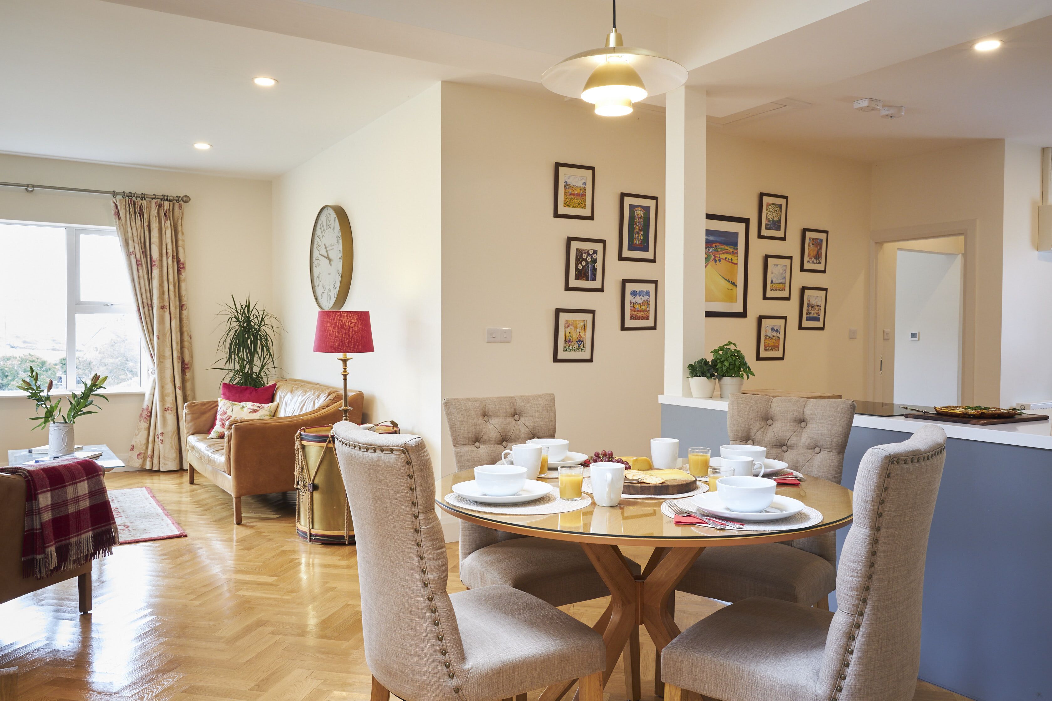 Un espace repas comprenant une table ronde, des chaises et une variété d’articles de table.