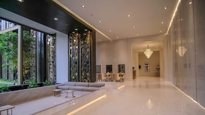 Un hall d’entrée spacieux, doté d’un sol en marbre, d’un espace salon et d’un lustre.
