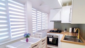 Een moderne keuken met witte kastjes, een houten aanrechtblad en een ingebouwde oven.