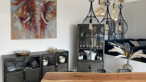 A dining area with a wooden table, chairs, a cabinet with glass doors, and a hanging light fixture.