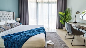 A modern bedroom with a bed, a desk, and a chair. - Downtown Charming Condo Close to Dubai Mall (Dubai)
