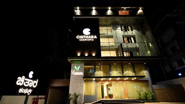A modern hotel with a prominent sign for 'Chithara Comforts' and another sign for 'Vivaam'. - Chithara Comforts (Udupi)