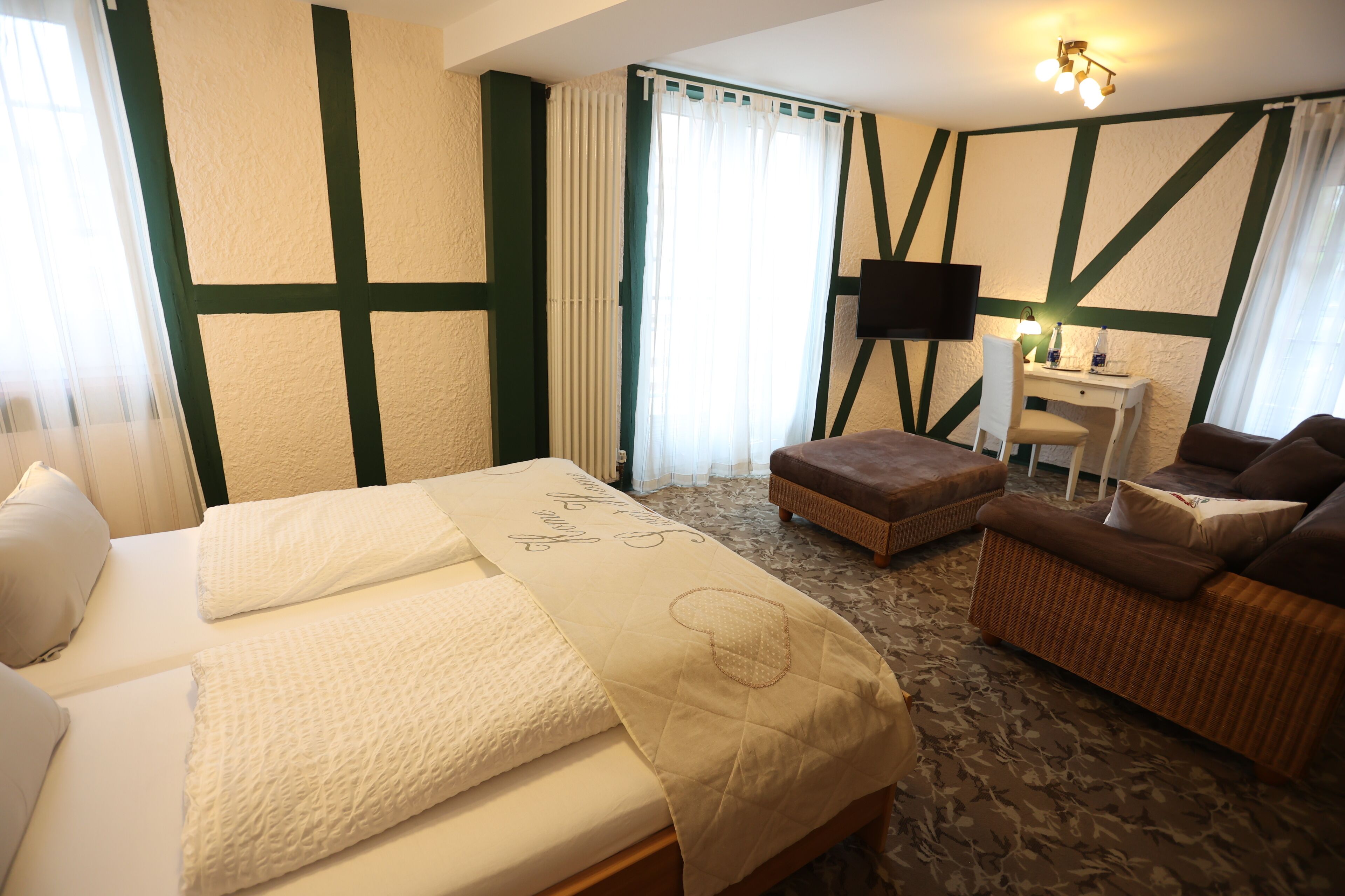 Ett hotellrum med en säng, ett skrivbord, en stol och en soffa.