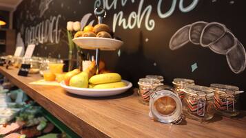 Un buffet de petit-déjeuner proposant une variété de fruits, de viennoiseries et de boissons.