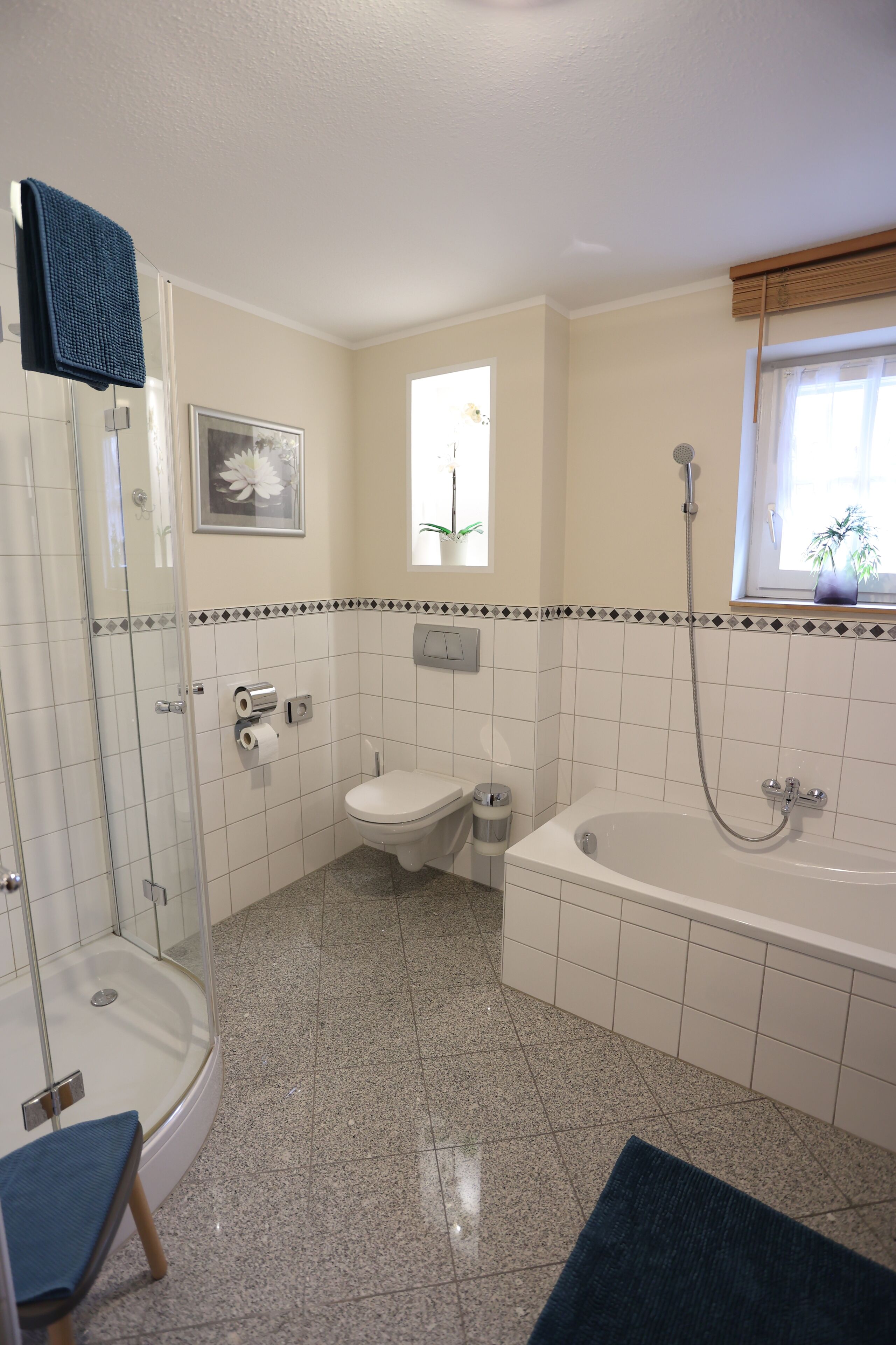 Un baño con cabina de ducha de vidrio, inodoro, bañera y ventana con vistas al exterior.
