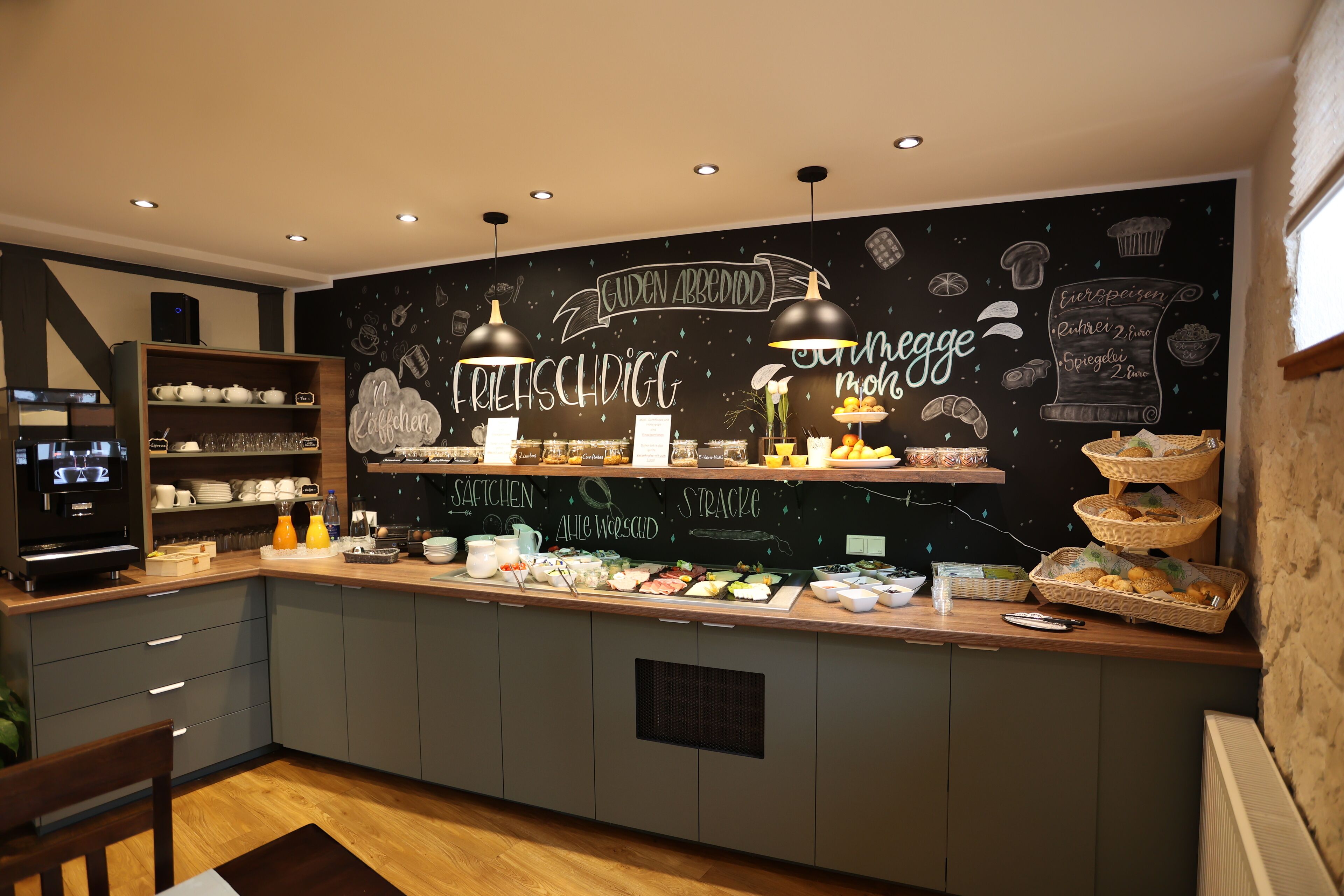 Eine moderne Küche mit einer Kreidetafel, auf der Lebensmittel und eine Kaffeestation abgebildet sind.