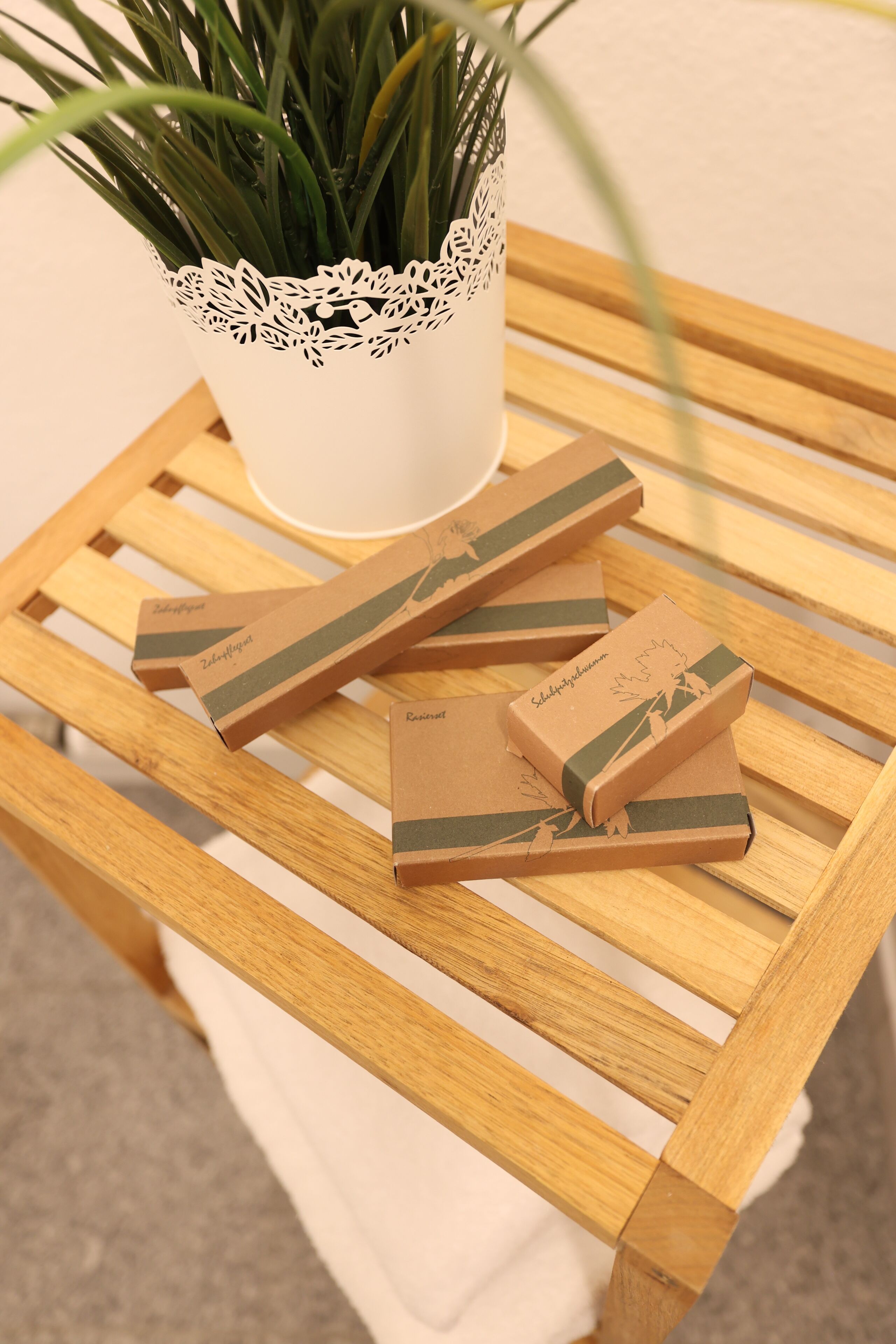 Une table en bois sur laquelle se trouvent un pot blanc et plusieurs petites boîtes.