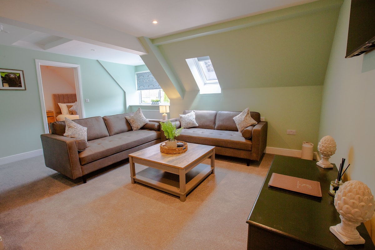 A modern living room with a sectional sofa, a coffee table, and a small side table with decorative items.