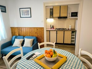 Cozy living space with a kitchenette, sofa, and dining table.