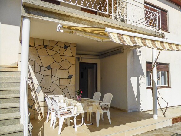 Relax in this serene outdoor seating area with a table and chairs, perfect for enjoying the surroundings.