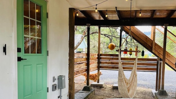 A cozy outdoor hot tub area with a green door, wooden deck, and a hammock. - The Weekender | Hot Tub| Neskowin Village (Neskowin)