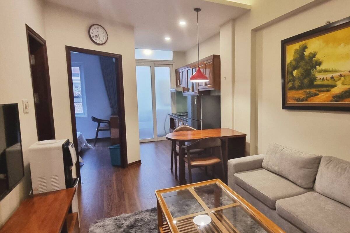 A living room with a sofa, a coffee table, a TV, and a painting on the wall.