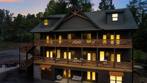 Un lodge su due piani con un balcone e una zona salotto esterna coperta.