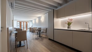 A modern kitchen with a built-in stove, a sink, and a countertop with a vase of flowers. - Palace Canal View by Wonderful Italy (Venice)