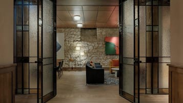 A lobby with a stone wall, a sofa, and a table.