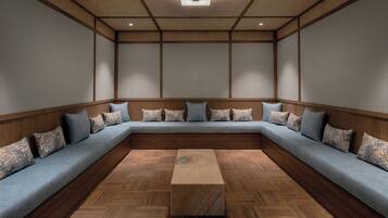 Una habitación con un amplio sofá modular en forma de L, una mesa de centro de madera y un suelo de madera con estampado de espiga.