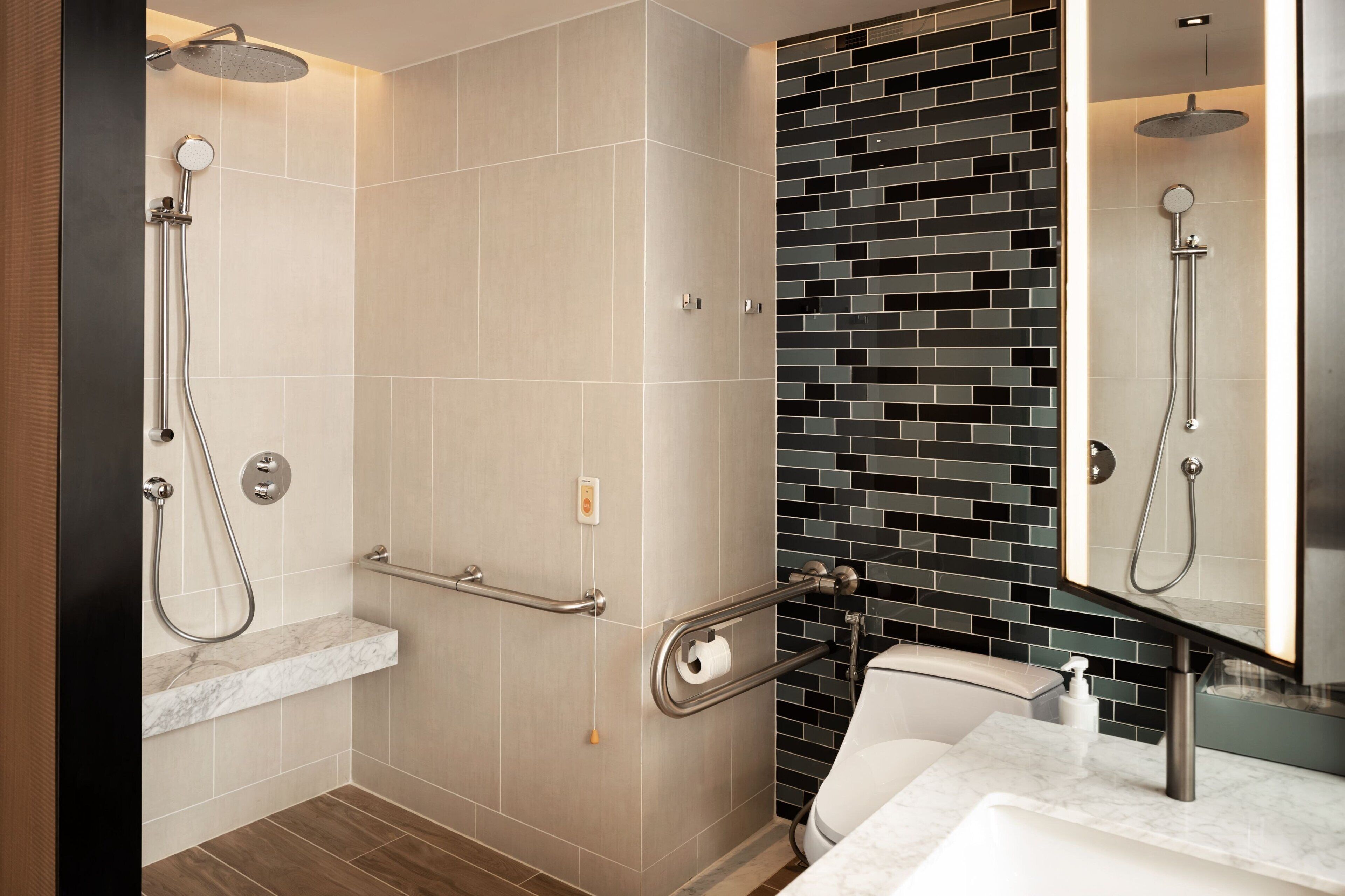 A modern bathroom with a shower, toilet, and sink.