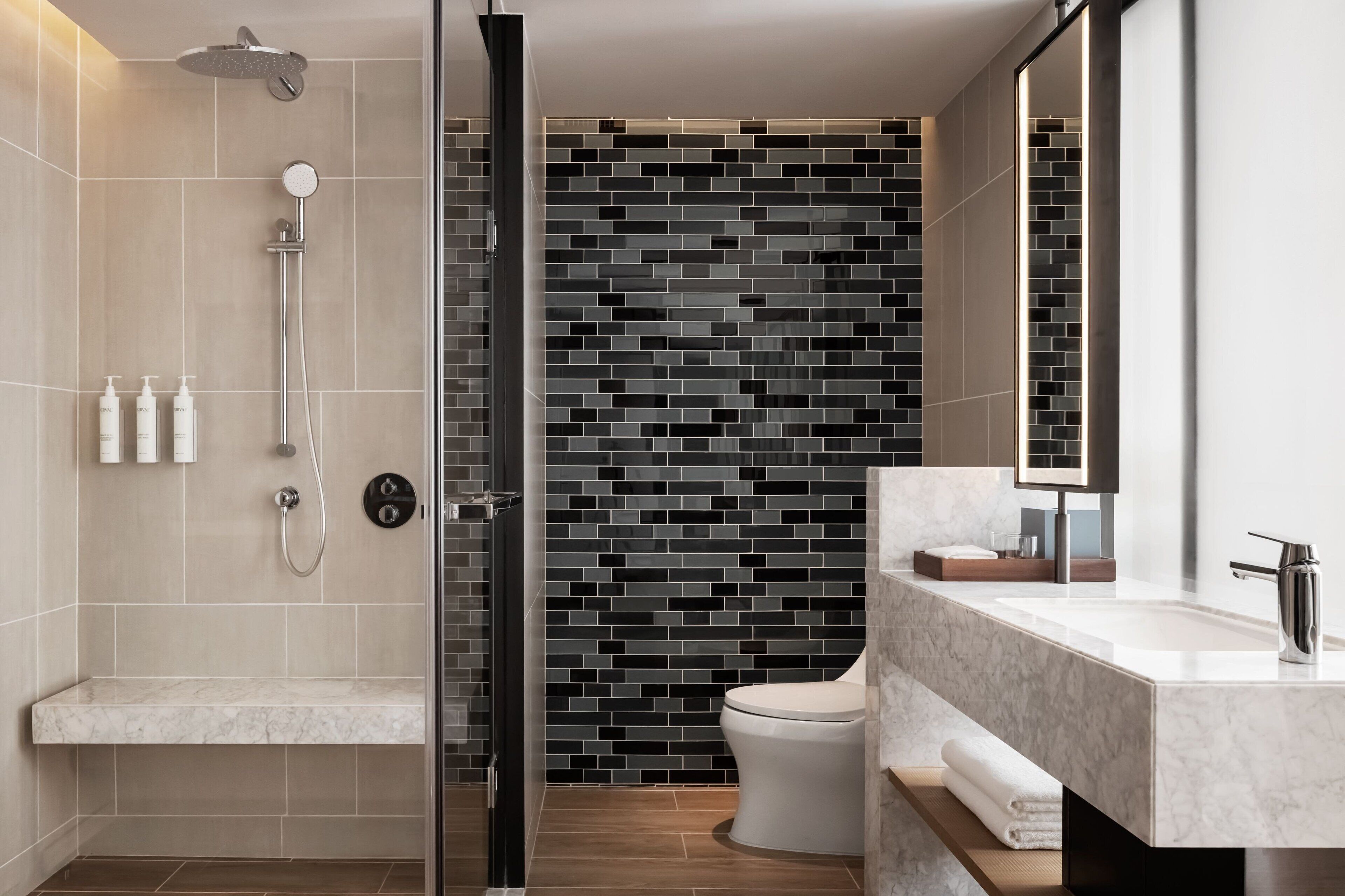 A modern bathroom with a shower, toilet, and vanity.
