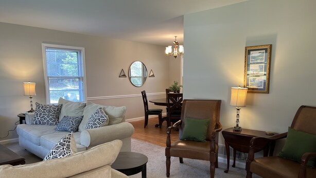 A living room with a sofa, chairs, a dining table, and a chandelier. - 2.0 to the Masters! (Augusta)