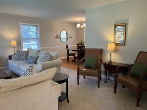 A living room with a sofa, chairs, a dining table, and a chandelier. - 2.0 to the Masters! (Augusta)