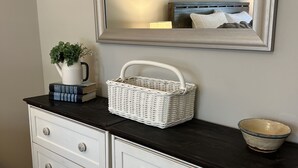 A white dresser with drawers, a mirror above it, and a small white basket on top. - 2.0 to the Masters! (Augusta)