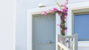 A white building with a light blue door, a white staircase, and a window with a blue frame. - Deluxe Apartment (Thasos)