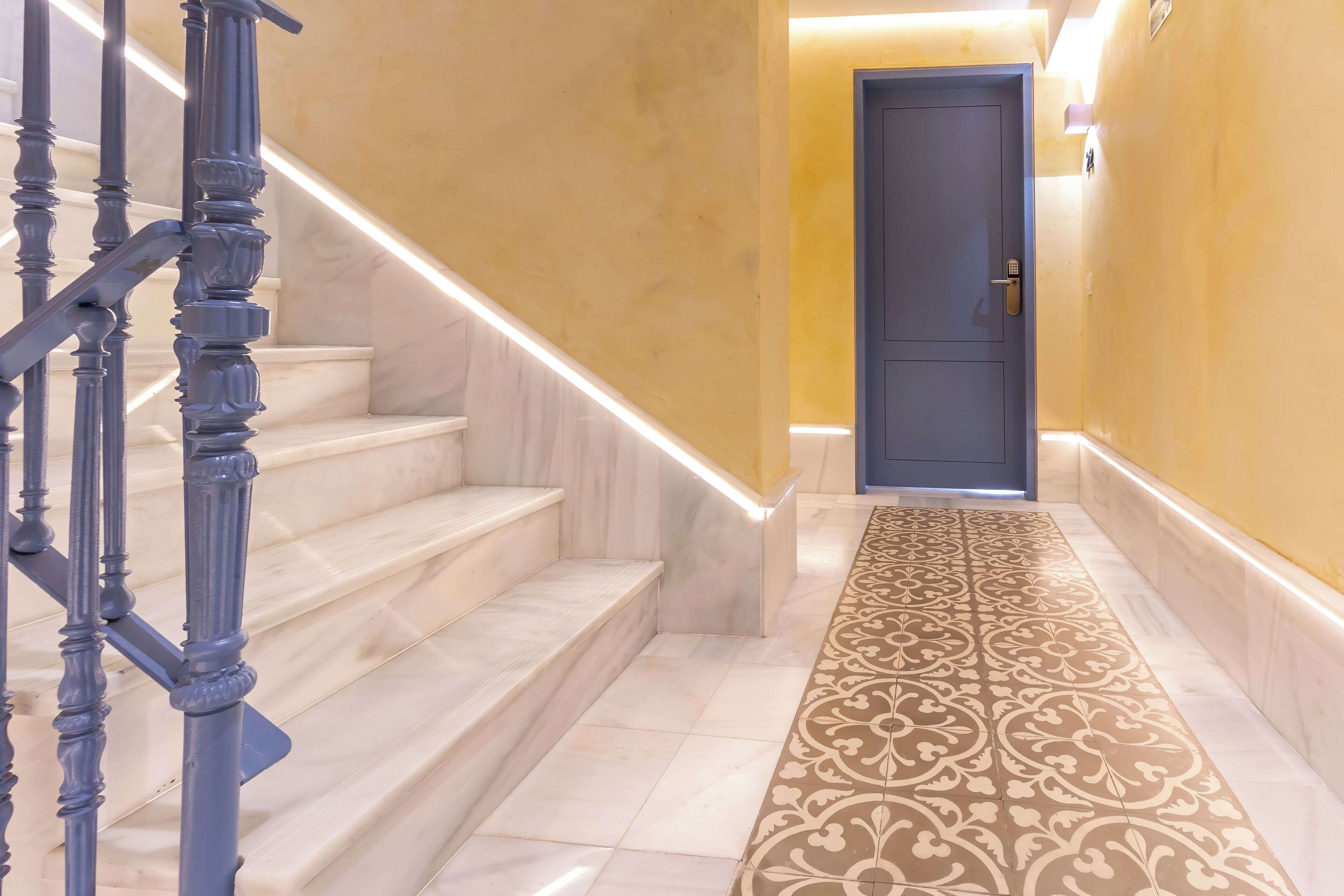Una escalera con alfombra estampada que lleva a una puerta.