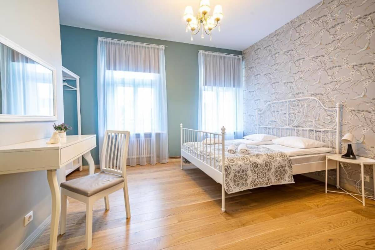 Un dormitorio con cama, escritorio, silla y mesita de noche.