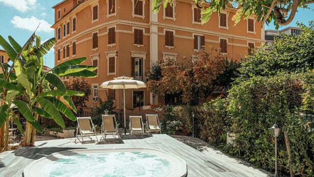 A pool area with a hot tub, lounge chairs, and an umbrella. - ALBERGO RISTORANTE BELSITO FIUGGI Nhost (Fiuggi)