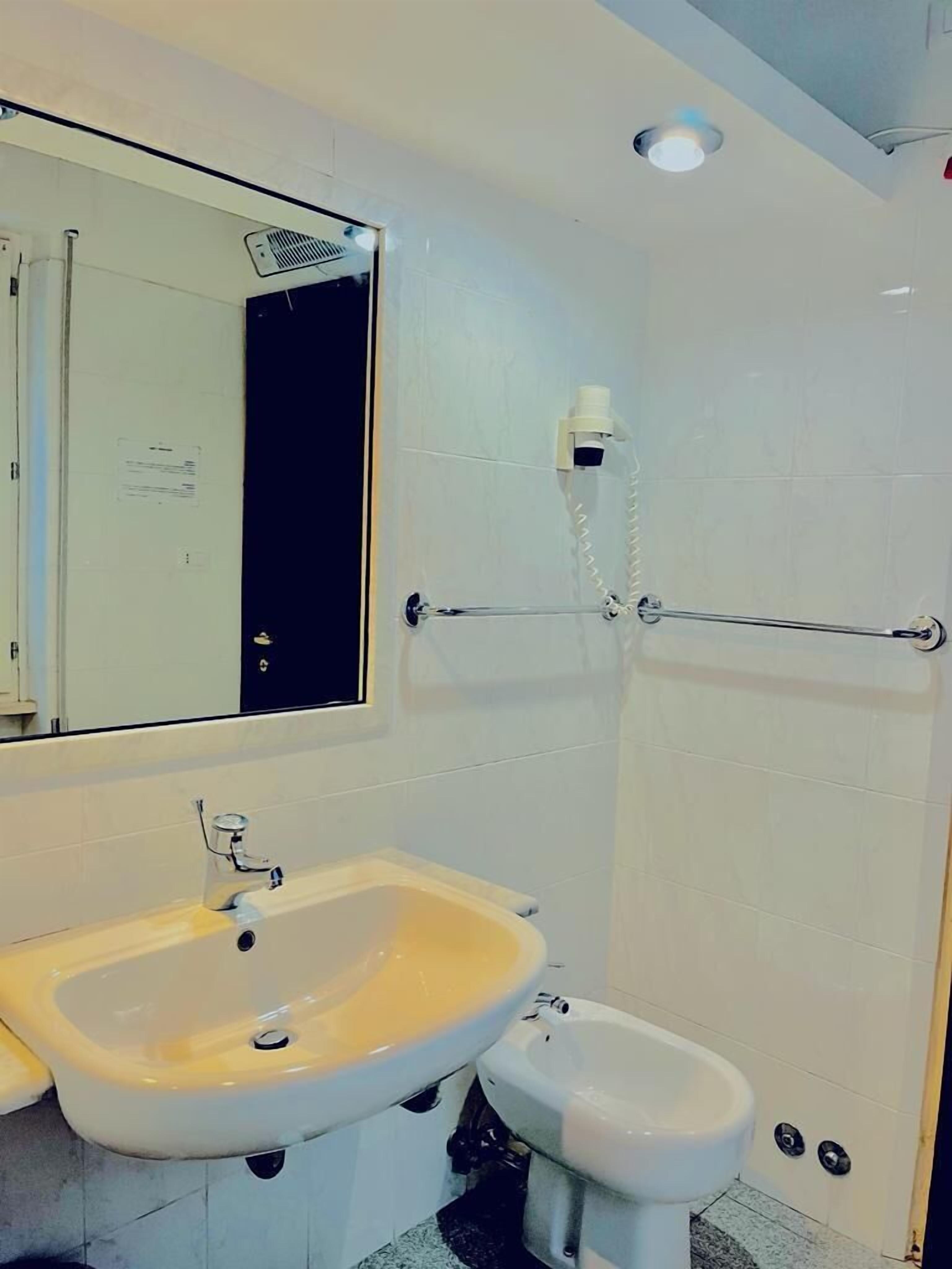 A bathroom with a sink, toilet, and shower.