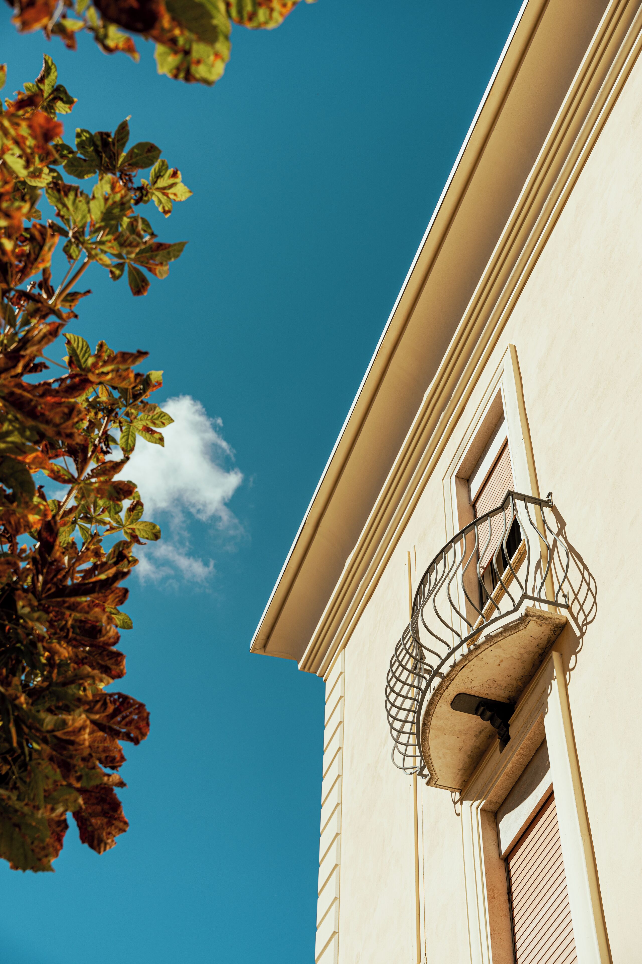 Un coin d’immeuble avec une fenêtre et un balcon.