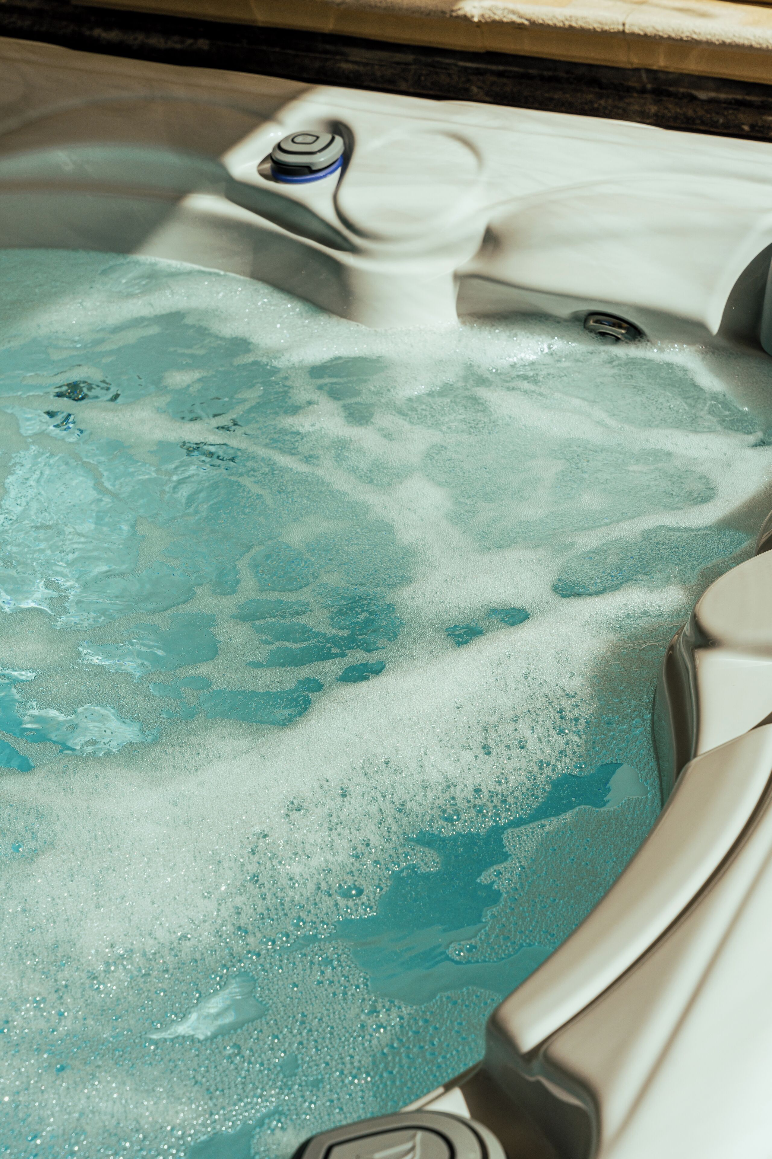Un bain à remous doté d’un panneau de commande et d’un drain visible.