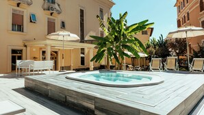 A rooftop pool area with a hot tub, lounge chairs, and umbrellas. - ALBERGO RISTORANTE BELSITO FIUGGI Nhost (Fiuggi)