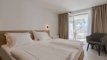 A hotel room with a large bed, a chair, and a view of the outdoors.