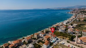 An aerial view of a coastal town with a mix of residential buildings and a marina. - Villa Miki (Podstrana)