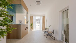 A modern hotel lobby with a reception desk, seating area, and large windows. - Villa Miki (Podstrana)