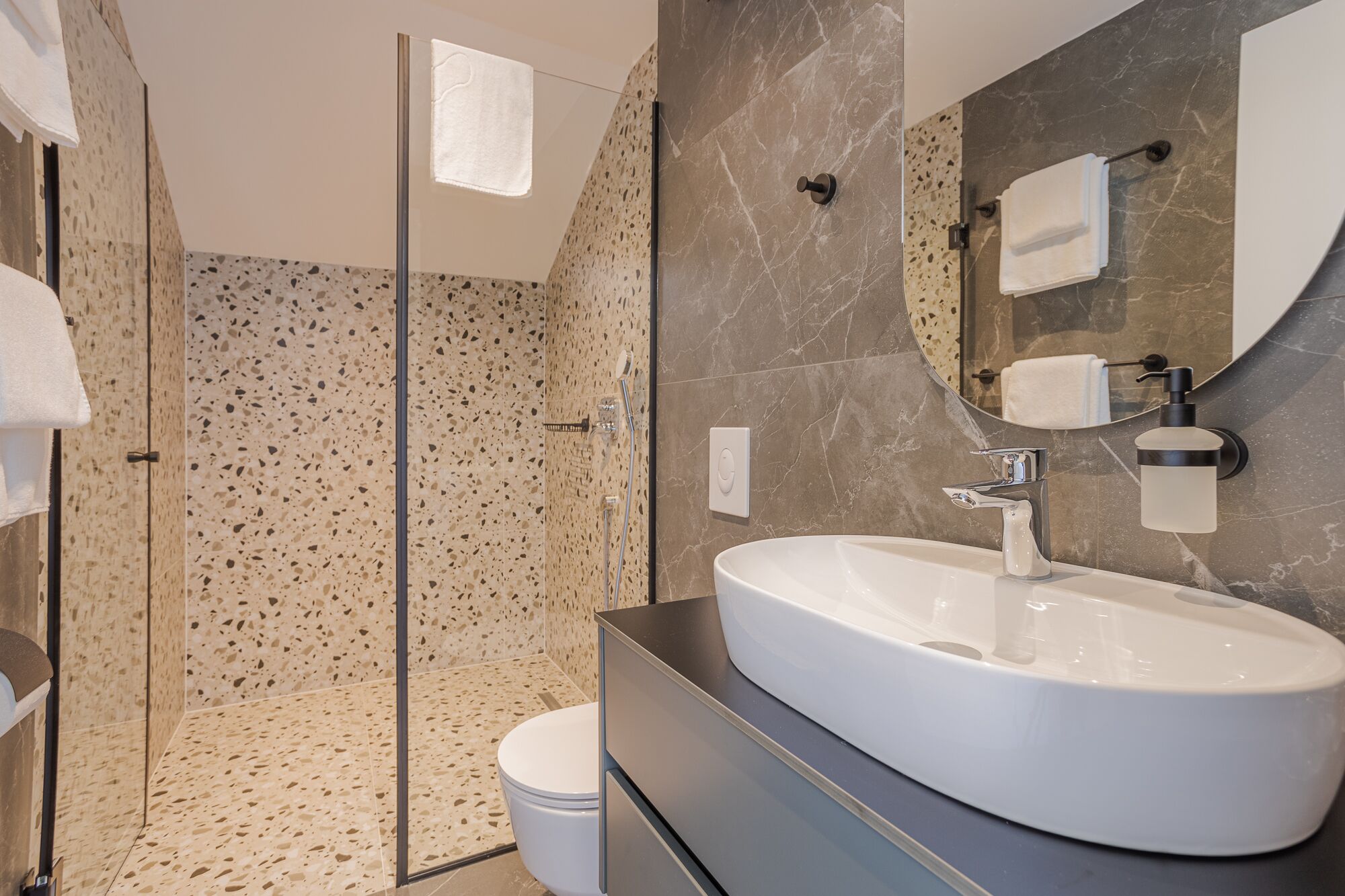 A modern bathroom with a freestanding bathtub, a glass-enclosed shower, and a large mirror.