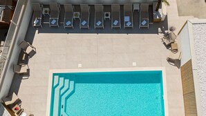 An aerial view of a rooftop pool area with multiple lounge chairs and a swimming pool. - Villa Miki (Podstrana)