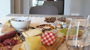 Uma mesa de jantar com diversos alimentos e uma taça de vinho.