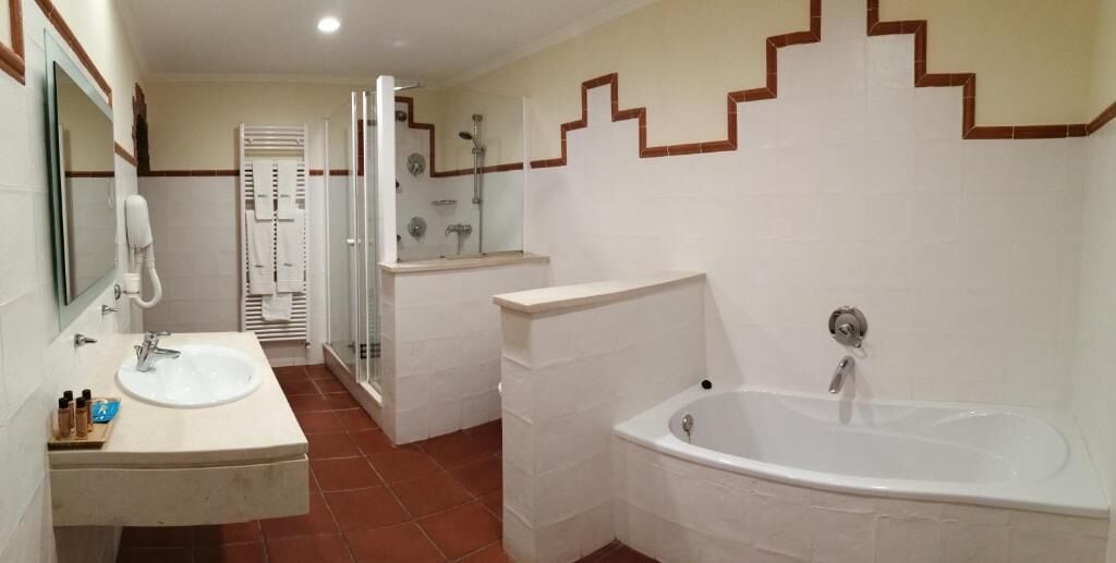 Un bagno con lavandino, specchio e vasca da bagno.