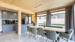 Una cocina moderna con armarios grises y una mesa de comedor de madera rodeada de sillas.