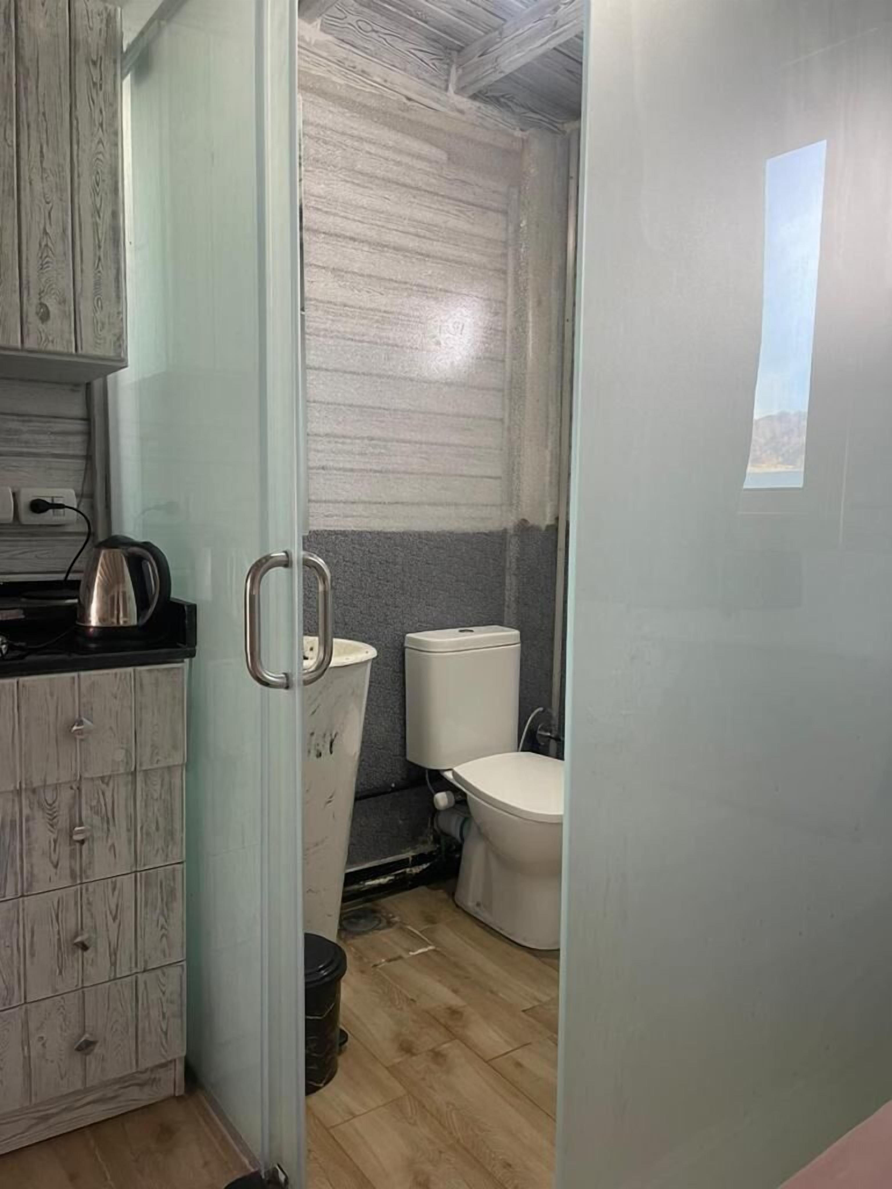 Casa de banho compacta com sanita, lavatório e armário.