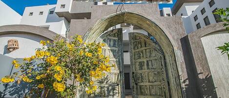 Entrada de un edificio con un letrero que dice "ELITE RESIDENCE" y una puerta de madera grande.