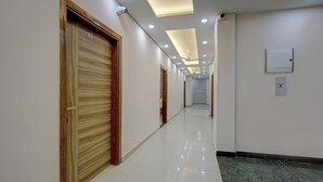 Um corredor com portas de madeira, iluminação embutida e piso ladrilhado.