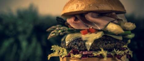 A burger on a wooden surface with a blurred background.