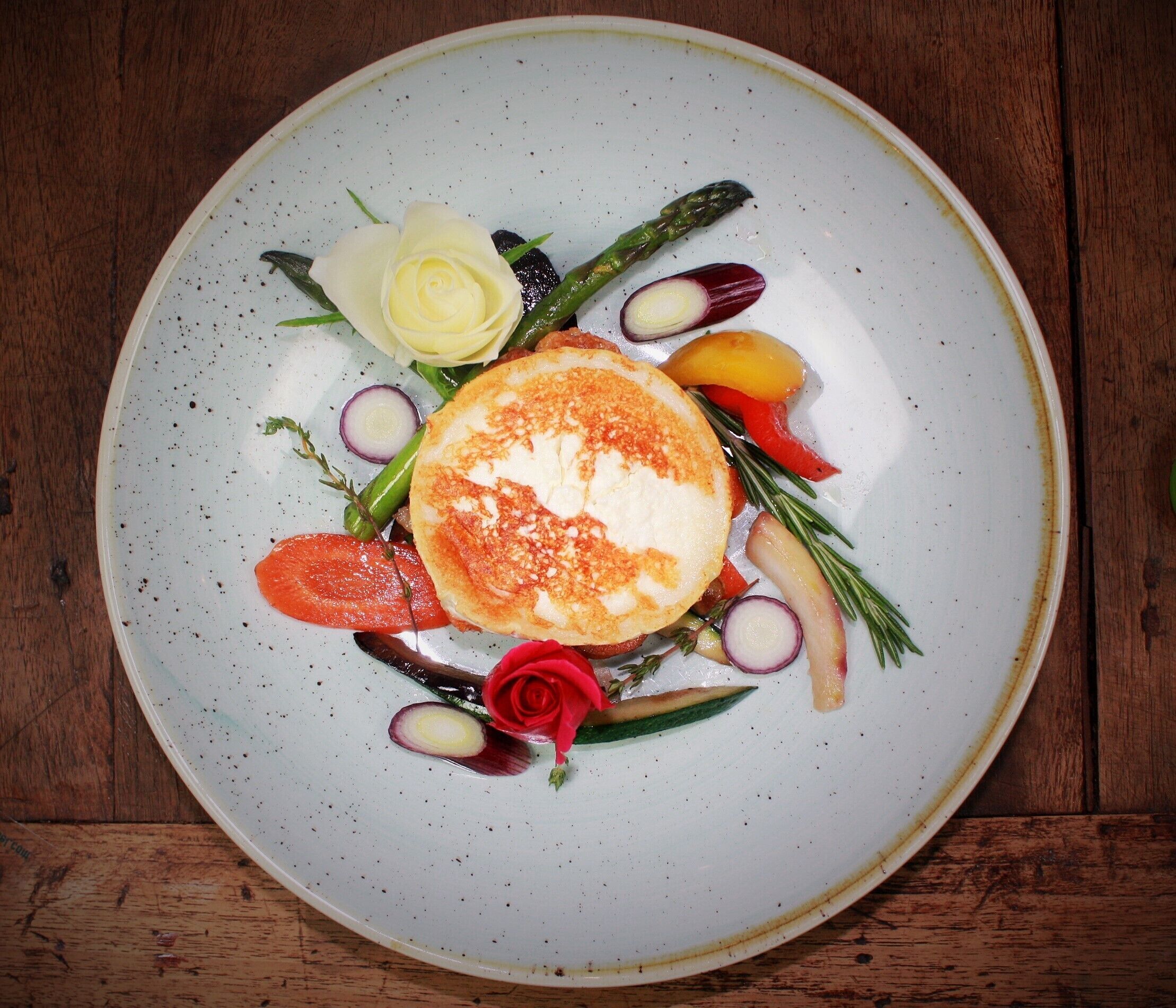 Une assiette remplie de différents légumes et ornée d’une rose.