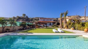 Une piscine aux eaux cristallines, avec une maison en arrière-plan.