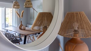 Un coin repas avec une table ronde, des chaises et des lampes en rotin suspendues au plafond.