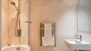 A modern bathroom with a glass-enclosed shower, a white sink, and a towel rack with a towel. - 1BR Apt Near Heathrow By Tempstay (Slough)
